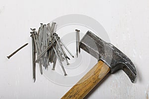 An old hammer and a handful of nails. On white background