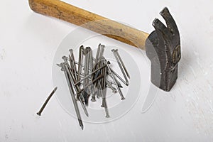 An old hammer and a handful of nails. On white background