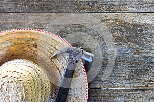 Old hammer and hat on old wood background