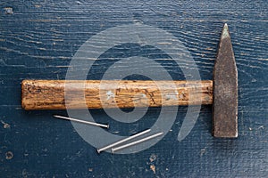 Old hammer and nails on blue table