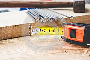 Old hammer with nails and a yellow ruler of roulette on a blackboard background. Tools for construction work