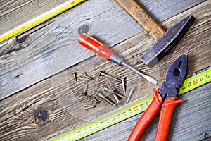 Old hammer, pliers, yellow measuring tape, vintage screwdriver a