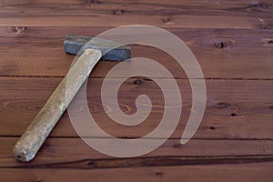 Old hammer on a wooden background