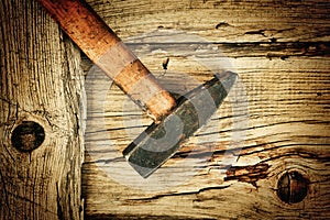Old hammer on the wooden planks