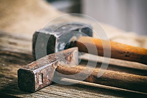 Old hammers on wooden background