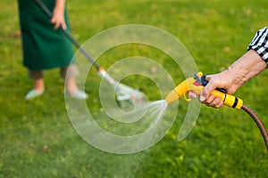 Old hand holding water hose.