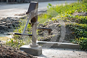Old hand-operated water pump standing on roadside in the