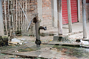 Old hand-operated water pump standing on roadside in the