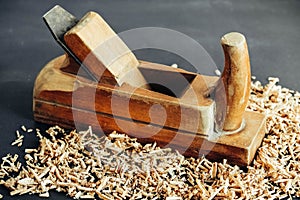 Old hand plane and wood shavings on black background. Old woodworking hand too on a black background. Copy, empty space for text