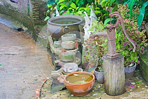 Old hand water pump and clay bowl.