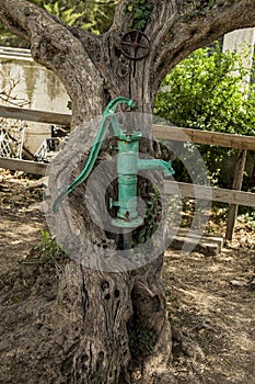 Old hand water pump on a well in the garden, watering and saving water in Austria.