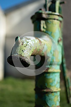 Old hand water pump on a well in the garden, watering and saving water, rural environnement