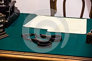 Old handcuffs on a table with green cloth