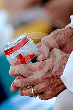 Old hands holding can