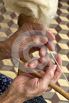 Old hands spinning wool.