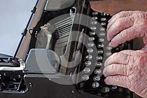 Old hands type on old typewriter