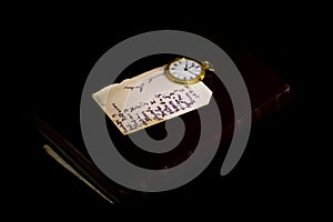 Old handwritten sheet and a pocket clock