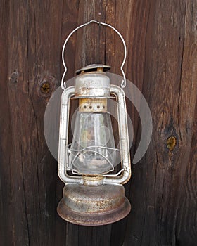 Old hanging kerosene lantern on wall.