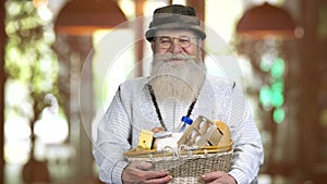 Old happy retired man carrying basket with uncooked food.