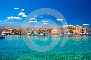 The old harbor of Chania with horse carriages, mosque and lighthouse.