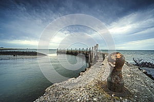 Old harbor, with mooring quay in a round concrete shape and a great view over the water and a threatening cloudy sky