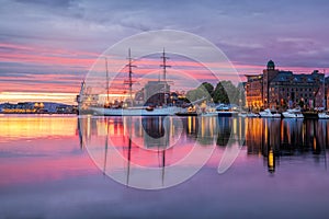 Old harbor with sail boat against sunset in Bergen. UNESCO World Heritage Site, Norway