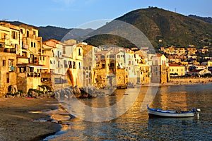 Old harbor at sunset with fishing boat, Cefalu, Sicily, Italy