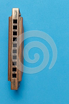 Old harmonica on a blue background.