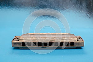 Old harmonica on a blue background.