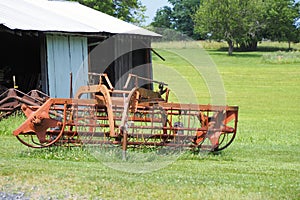 This old harvester is brown and rusted.