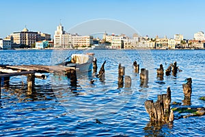 The Old Havana skyline and an old pier with fishing boats on the Bay of Havana