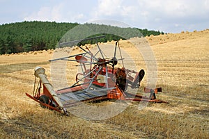 Old hay rake reaper-binder - rustic, oldfashioned farm equipment, used for field works during harvest season.