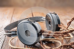 Old headphones. Close-up of vintage shabby headphones on wooden background. The concept of ancient radio engineering