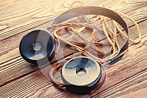 Old headphones for the radio. Close-up of vintage headphones with fabric wire on wooden background. The concept of ancient radio