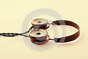 Old headphones. Yellow toning vintage radio headphones on a light background. The concept of ancient radio engineering