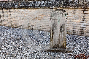 Old headstone on grave in abandoned cemetery.