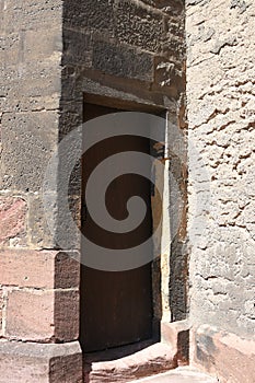 Old heavy square, wooden, massive door in stone wall to enter St. Martin`s Church