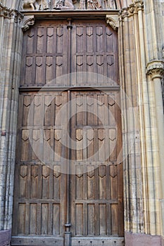 Old heavy square, wooden, massive, shafted door in stone wall to enter St. Martin`s Church in Gothic architectural style