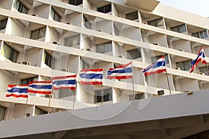 Old high rise condominium buildng with thailand flag in foreground