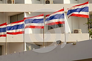 old high rise condominium buildng with thailand flag in foreground