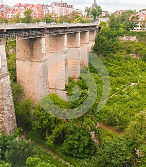 Old high stone bridge and walking people in Kamianets-Podilskyi, Ukraine