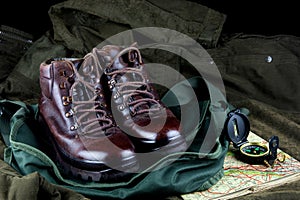 Old hiking Boots with Compass and Old Map on an Outdoor Bag and Field Coat