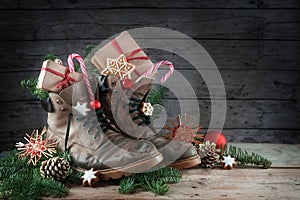 Old hiking boots filled with sweets, gifts and Christmas decoration on Nicholas day, or German Nikolaus Tag, on the 6th December