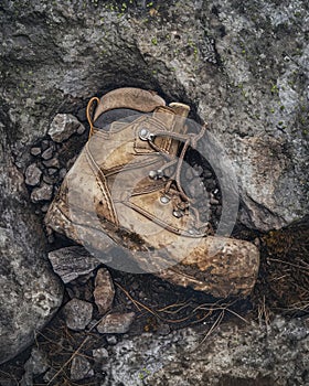 Old hiking boots on a rock in the mountains. Travel concept.