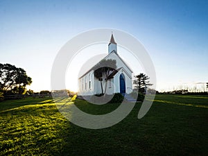 Old historic 19th century white presbyterian Awhitu Central Church with green grass, Manukau Heads Auckland New Zealand