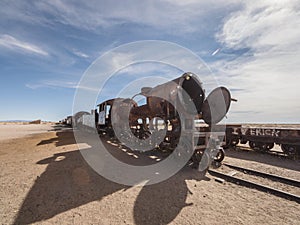 Old historic abandoned train engine locomotive ruins at Cementerio de Trenes cemetery graveyard, Salar de Uyuni Bolivia photo