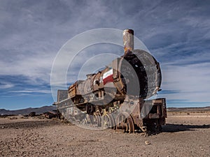 Old historic abandoned train engine locomotive ruins at Cementerio de Trenes cemetery graveyard, Salar de Uyuni Bolivia photo