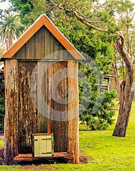 Old Historic Australian Toilet, Outhouse, Dunny on Green Grass. photo