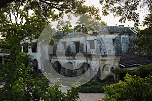 Old historic house view through tropical plants. Fort San Pedro view in sunset. Oldest historical fort in Philippines.