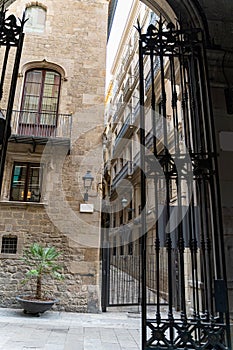 Old historic houses with windows, balconies and metal gate in Barcelona